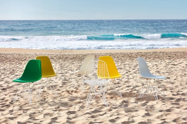 6 Eames shell chairs on the beach in different colours
