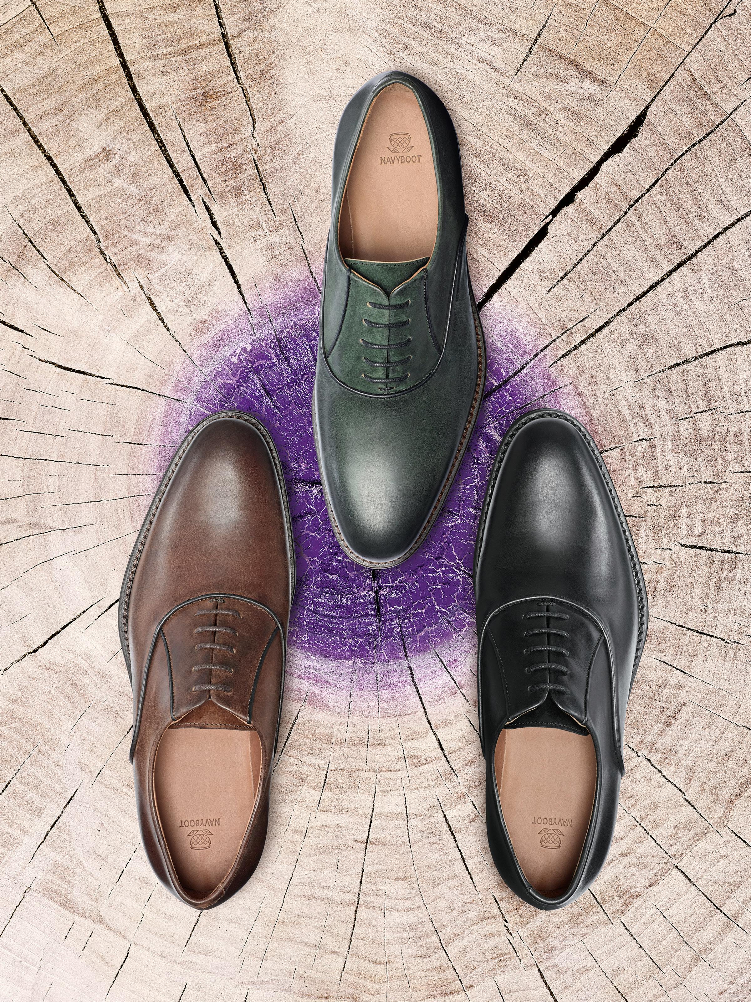 Three men's shoes on a wooden stump with purple paint
