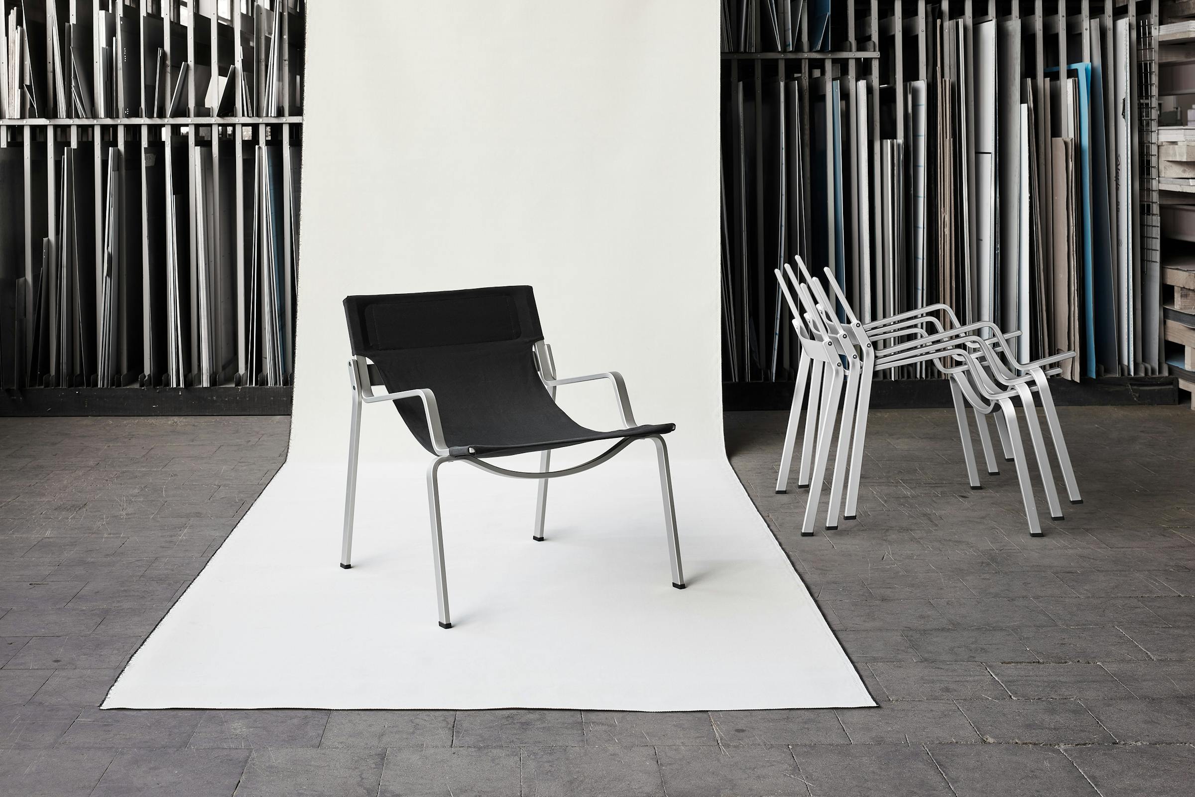 Product shot of the Enso chair by Frédéric Dedelley in front of a roll of Bananatex fabric at the Lehni factory.