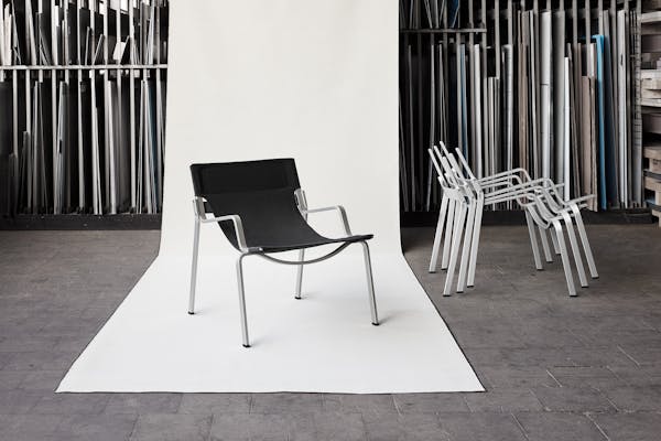 Product shot of the Enso chair by Frédéric Dedelley in front of a roll of Bananatex fabric at the Lehni factory.