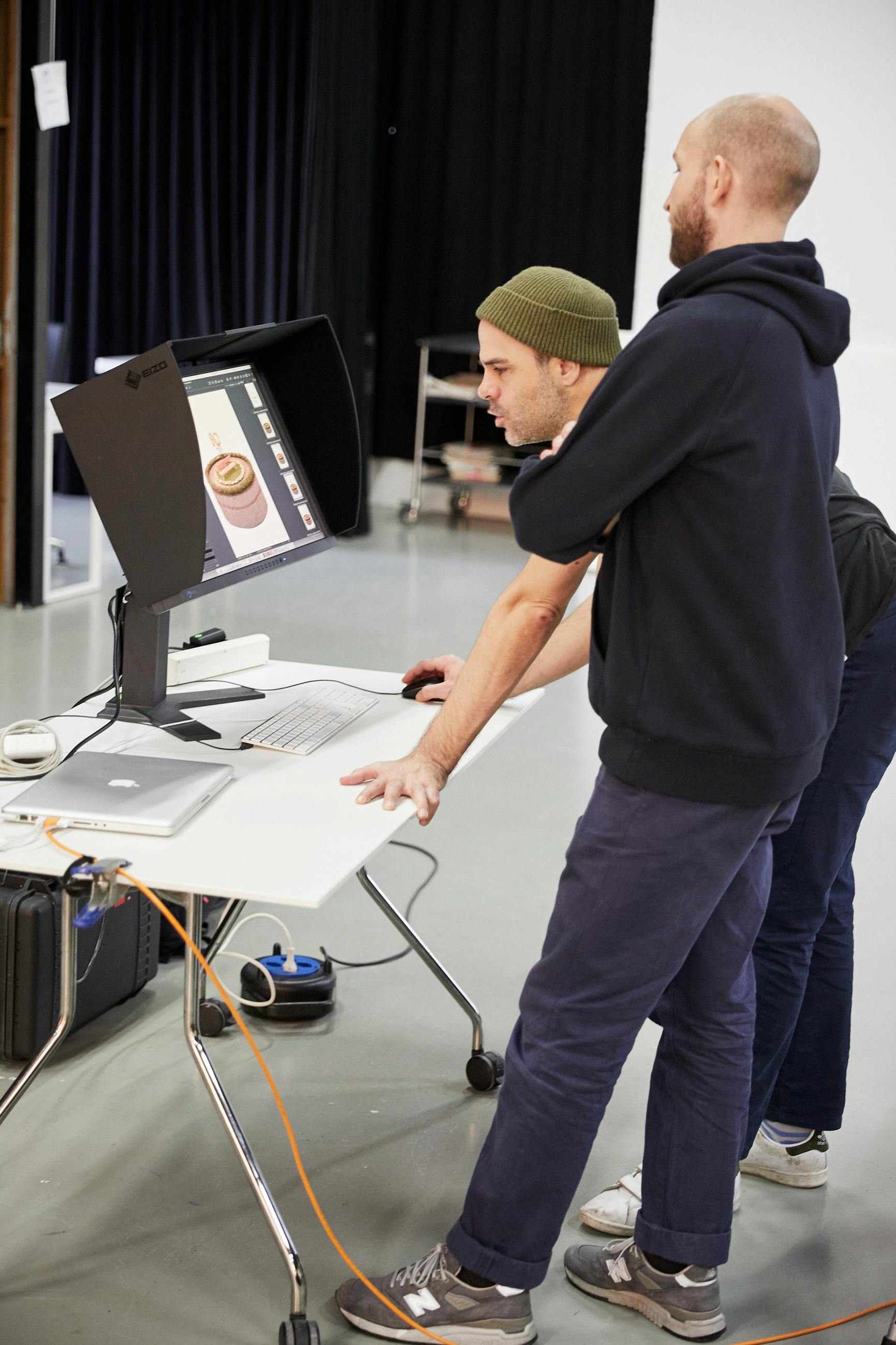 Backstage shot showing two men in front of a monitor