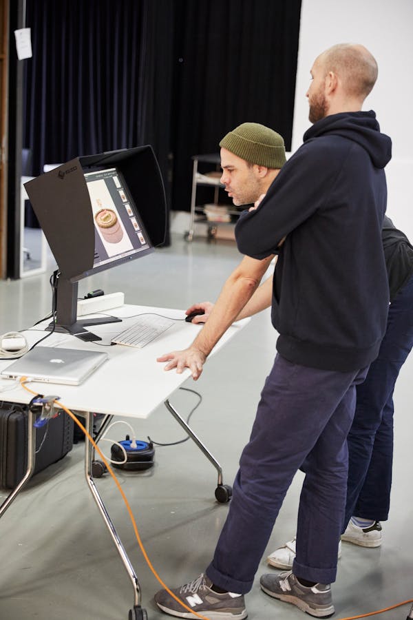 Backstage shot showing two men in front of a monitor