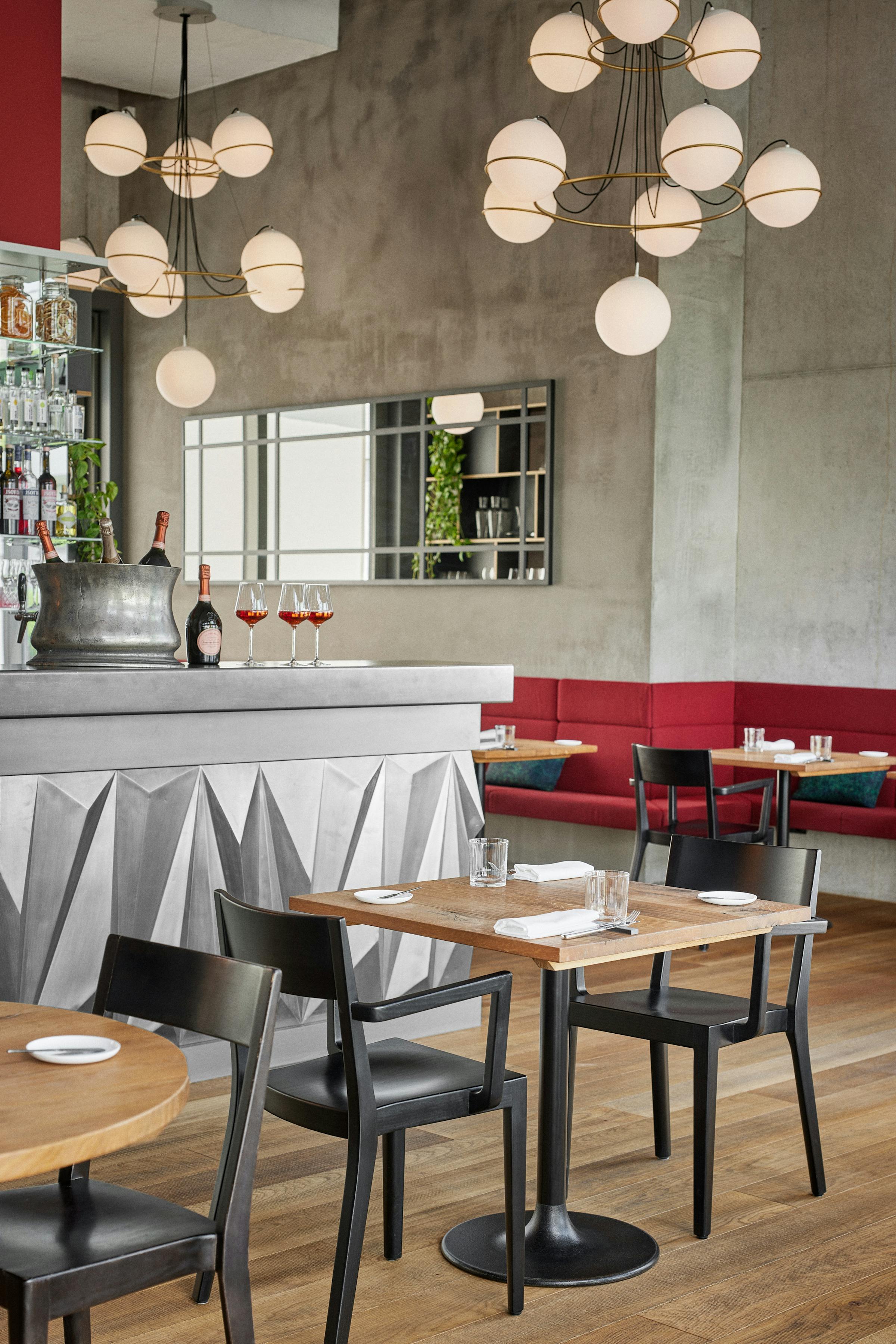 Two tables set fpr lunch in front of the bar in the restaurant Anna