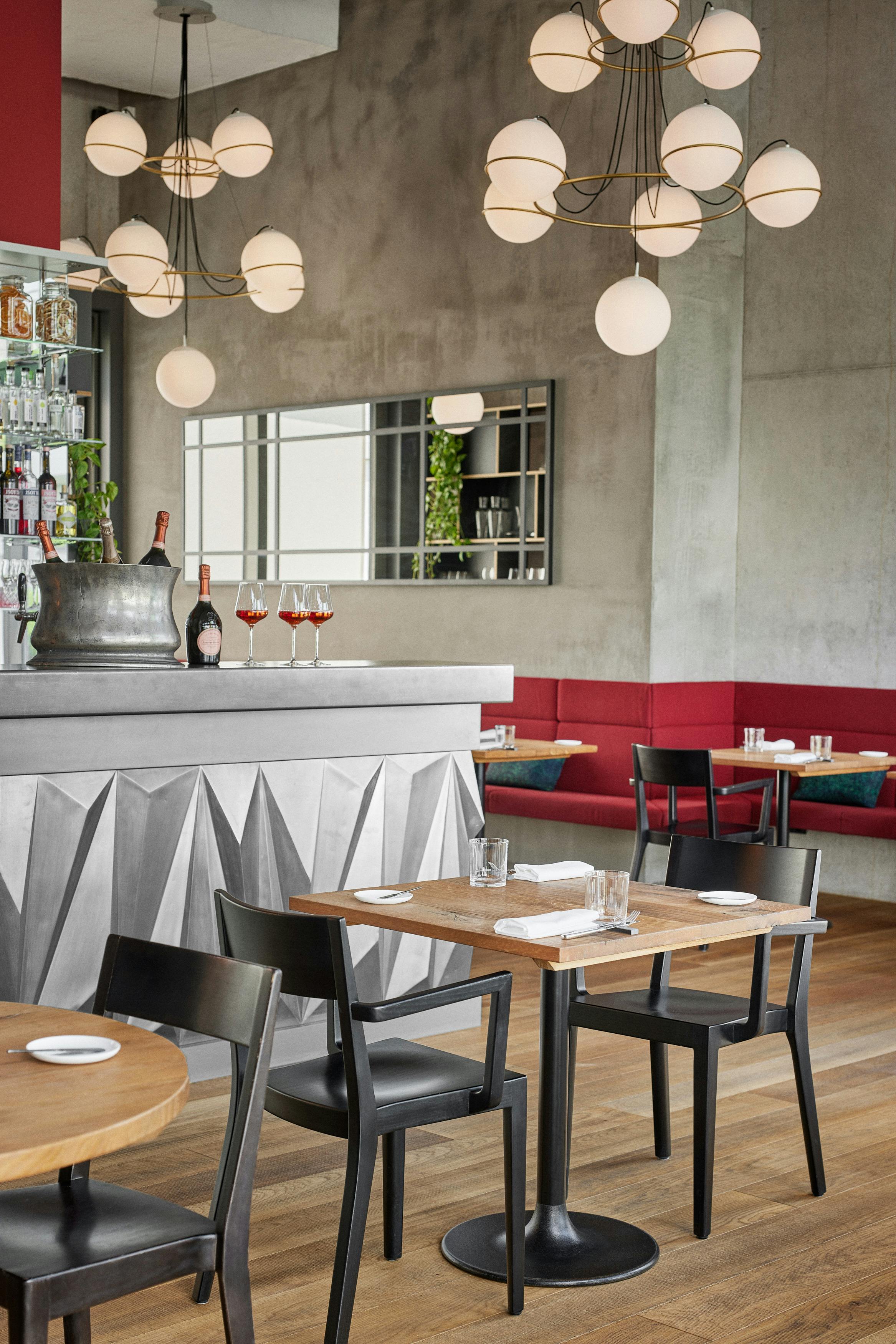 Two tables set fpr lunch in front of the bar in the restaurant Anna