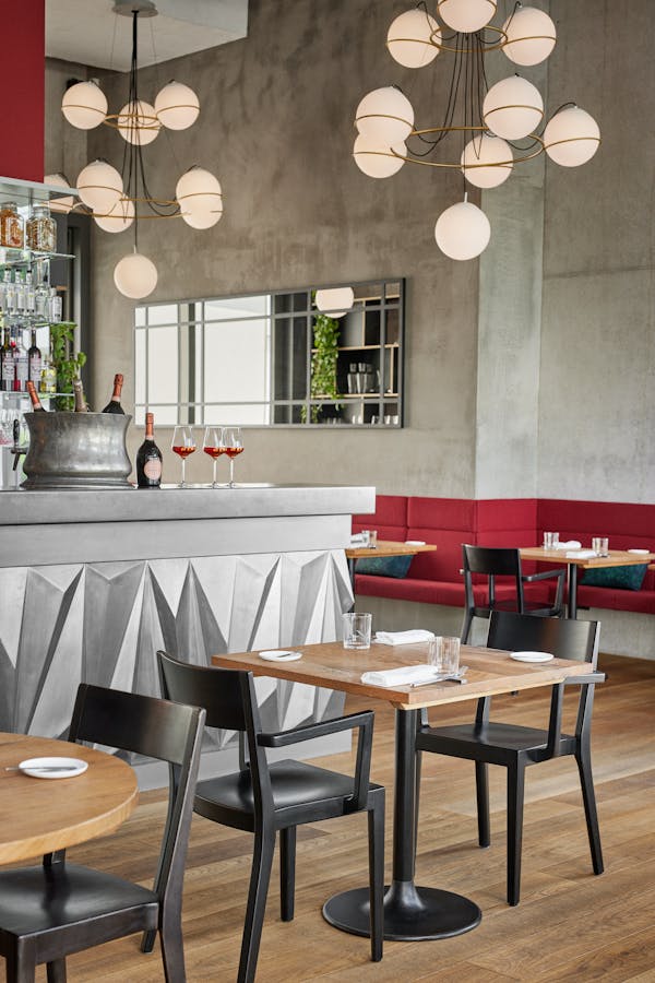 Two tables set fpr lunch in front of the bar in the restaurant Anna