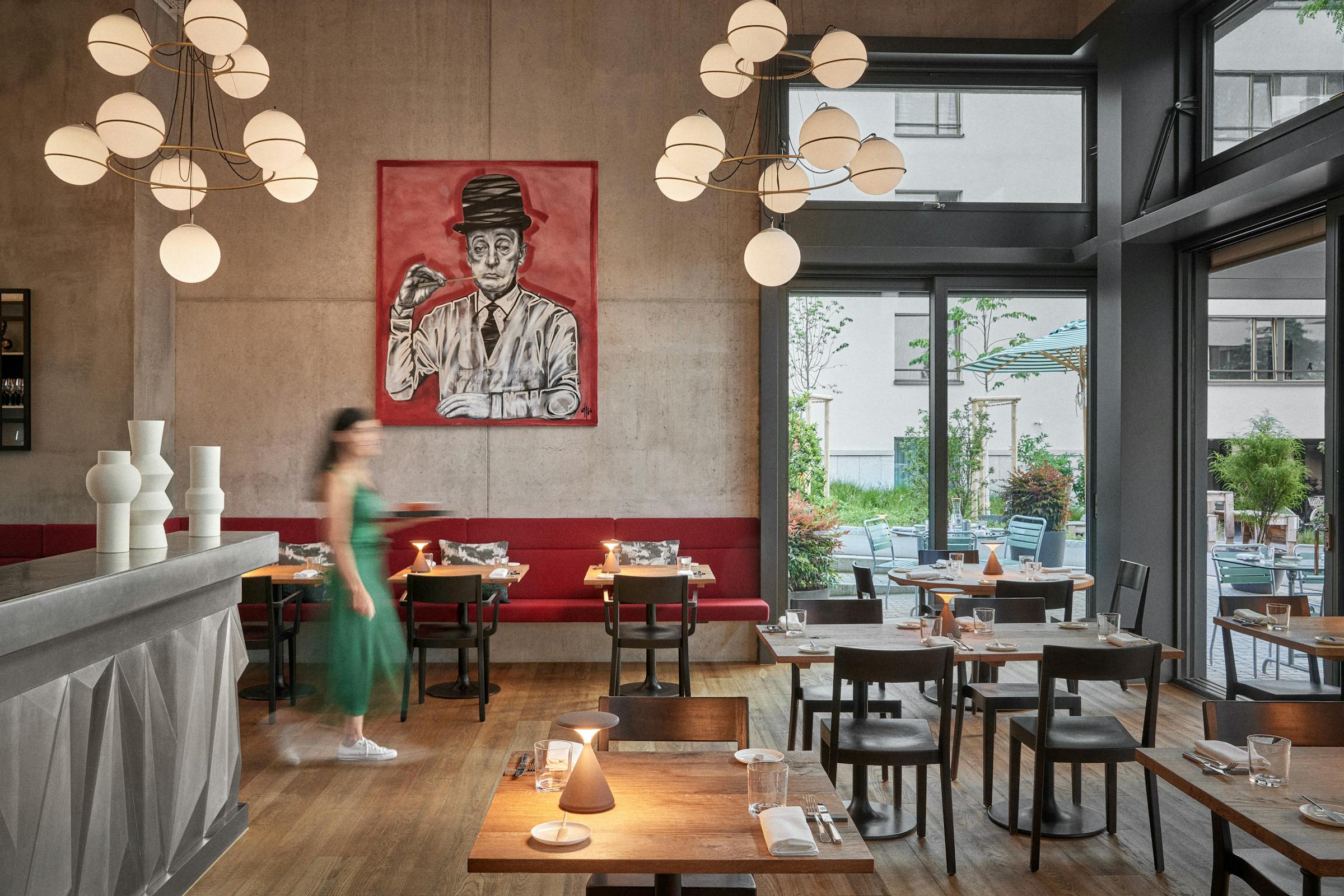 Interior shot at evening in the restaurant Anna with a woman in a green dress walking through