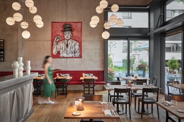Interior shot at evening in the restaurant Anna with a woman in a green dress walking through