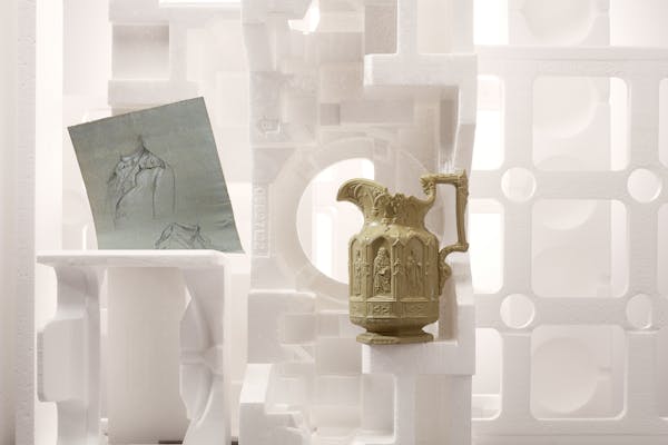 A classic pitcher in beige color standing in a set design made of white styrofoam objects