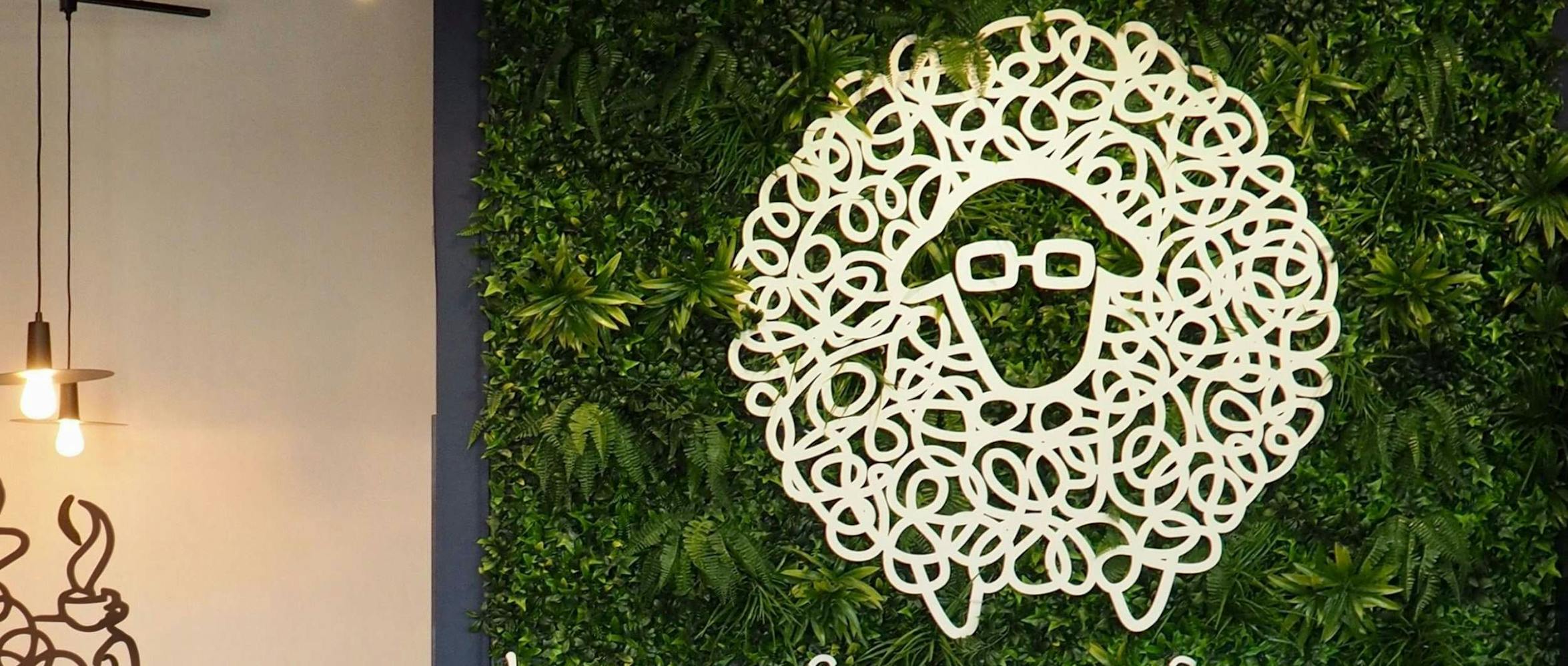 Lost Sheep Coffee logo on green plant background