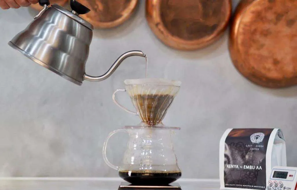 A swan neck kettle poring water over a v60 filter.
