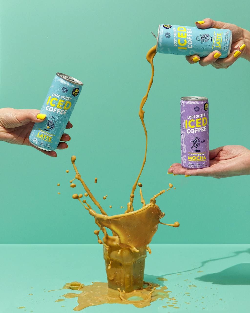 Cans of Lost Sheep Iced coffee being poured into a glass causing a splash