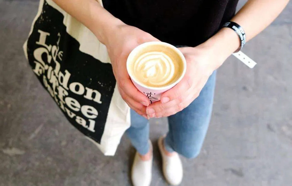 A person holding a cup of coffee at The London Coffee Festival