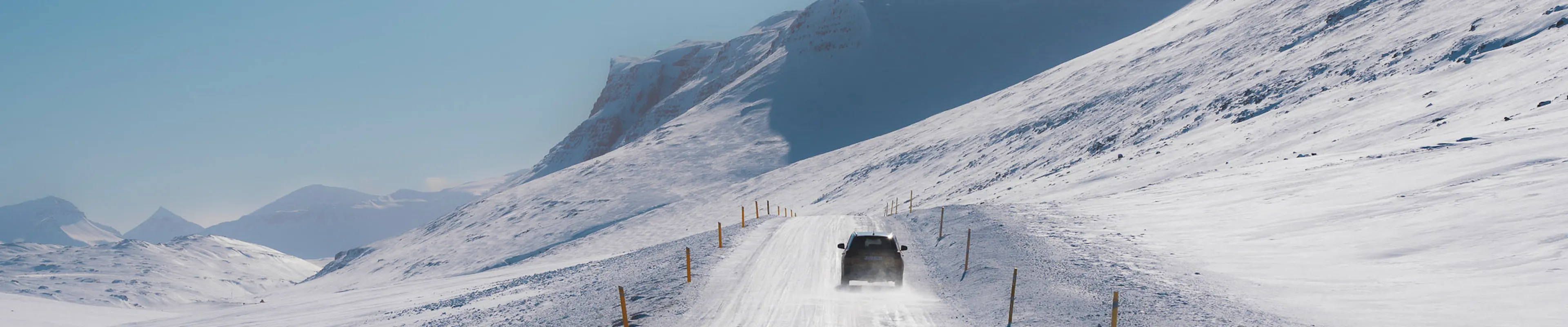 Suv driving snowy mountain road