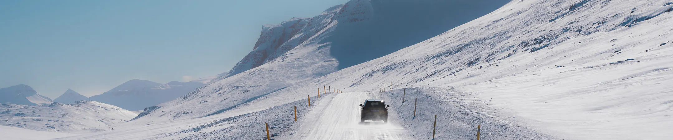 Suv driving snowy mountain road