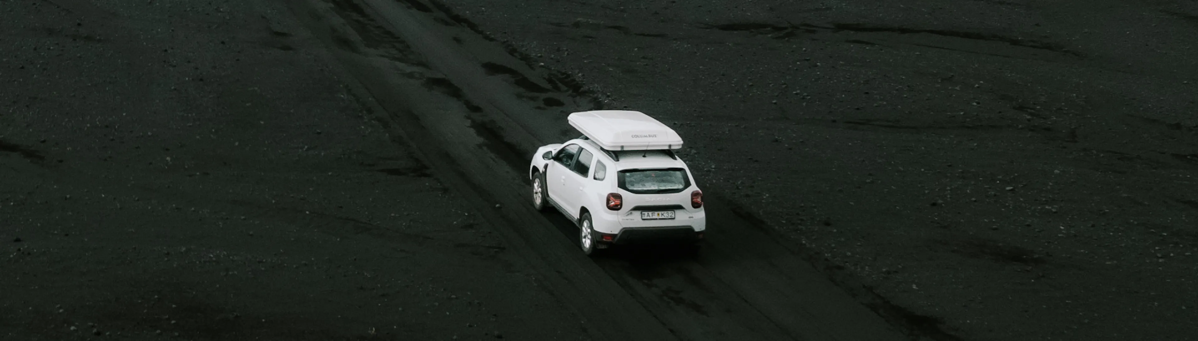 White suv rooftent black sand aerial