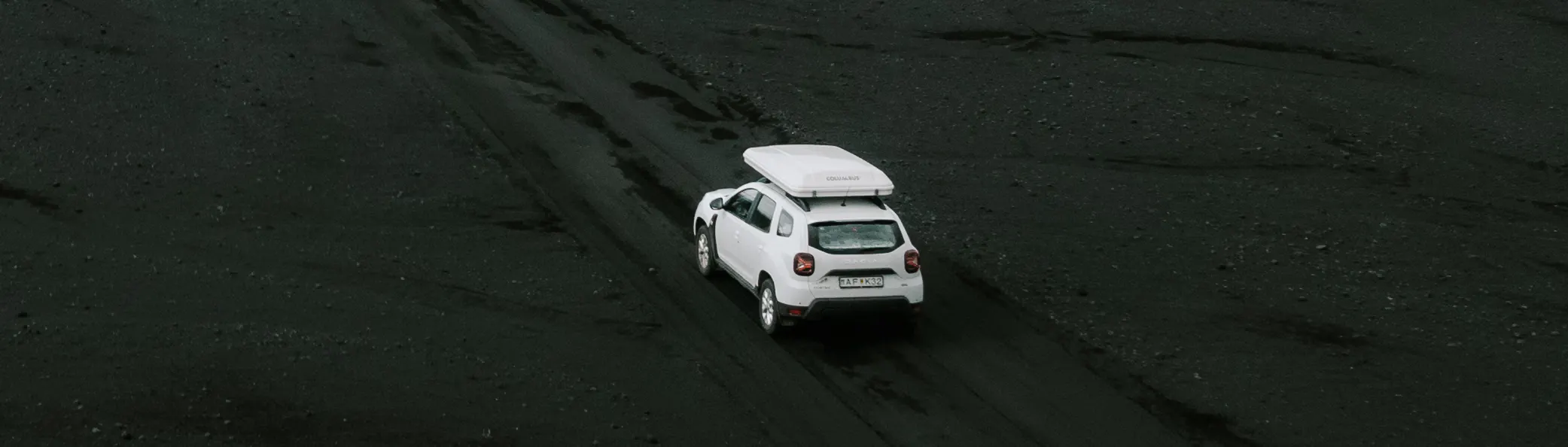 White suv rooftent black sand aerial