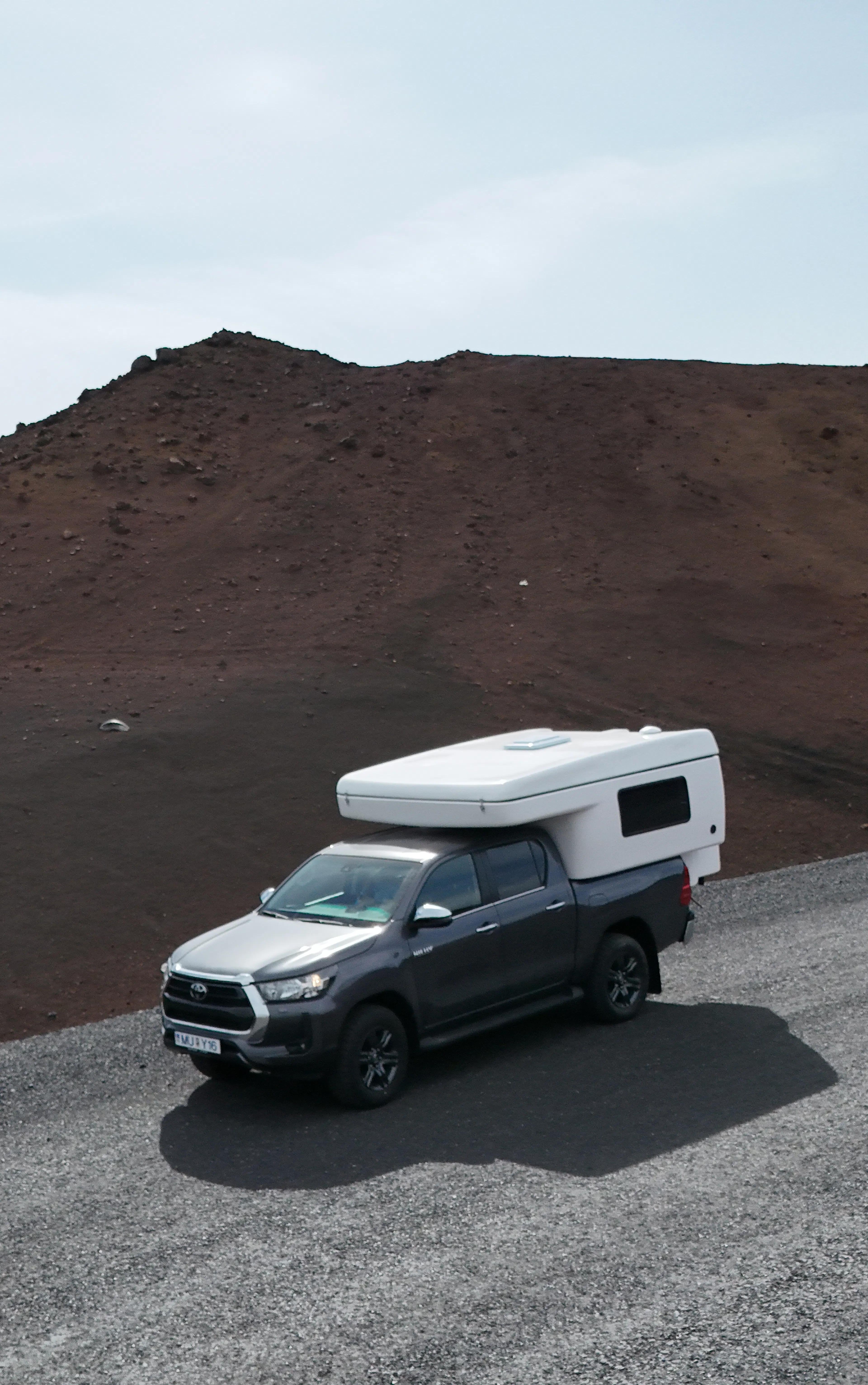 Pickup camper volcanic road aerial