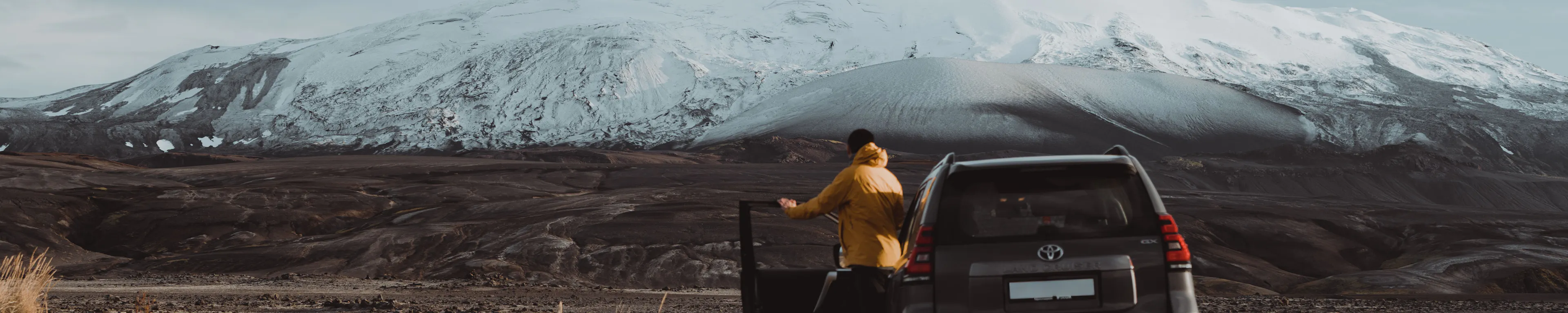 Traveler yellow jacket suv snowy mountain