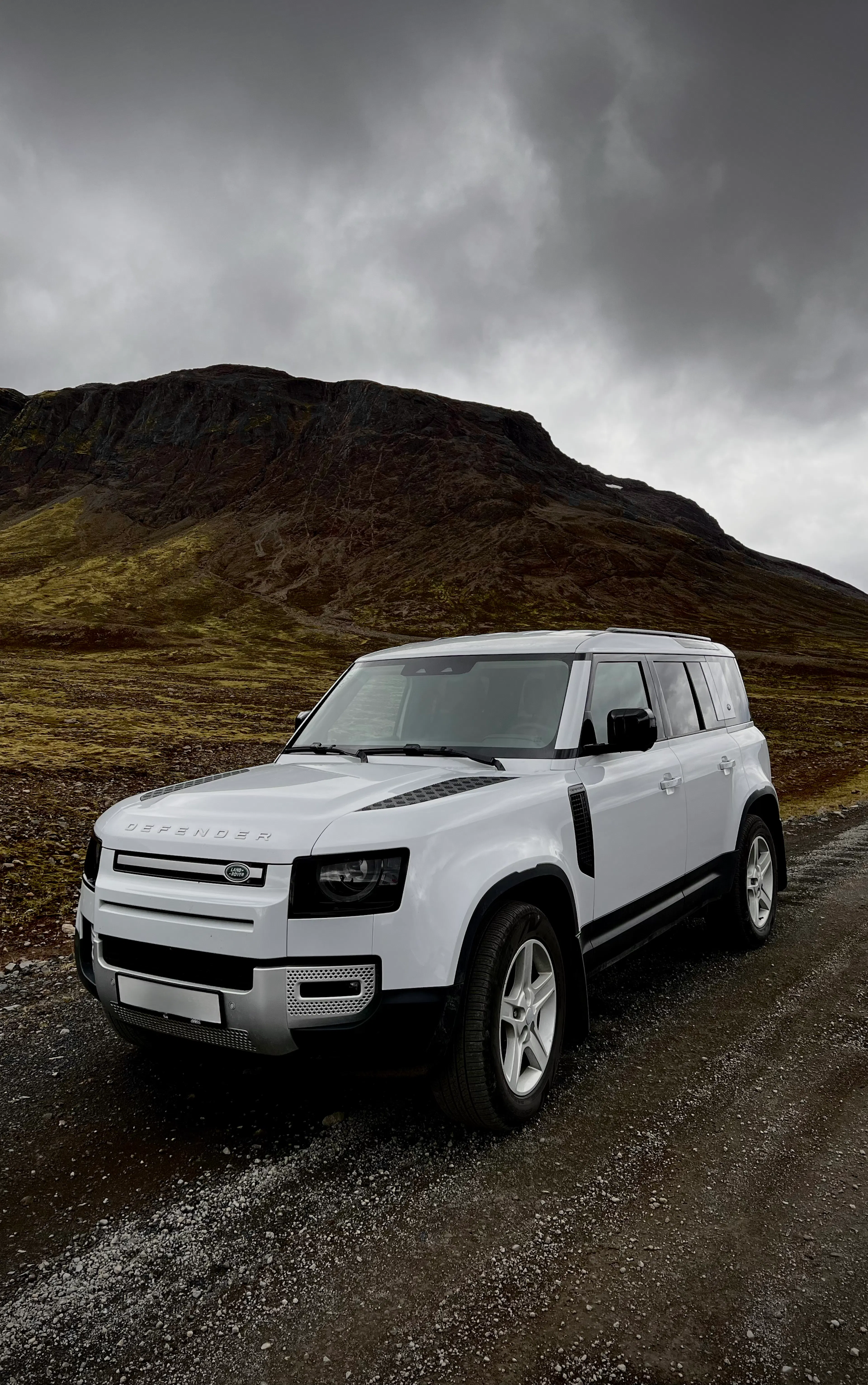 White defender gravel road mountains