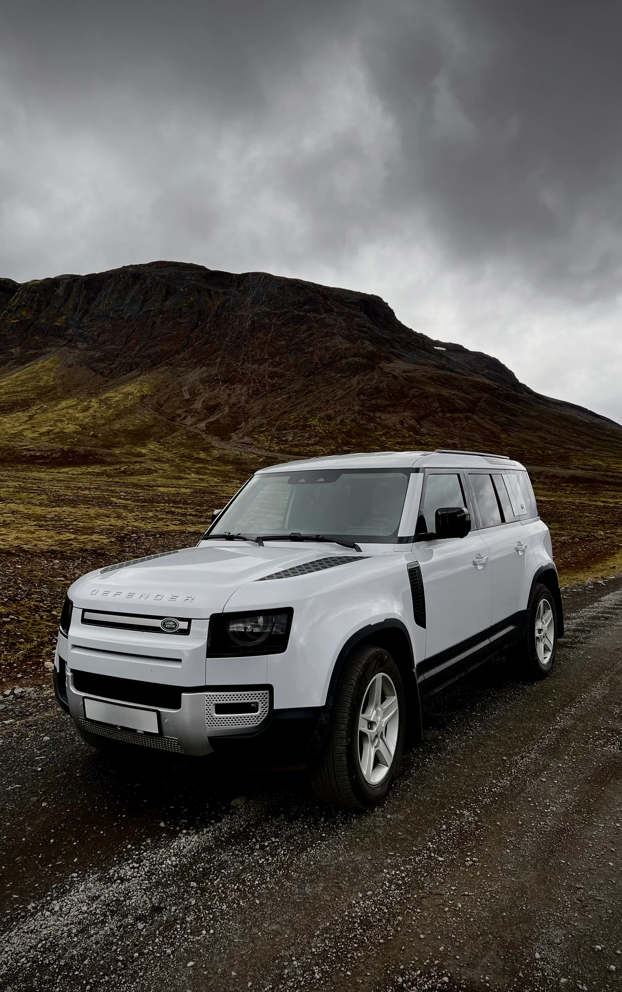 White defender gravel road mountains