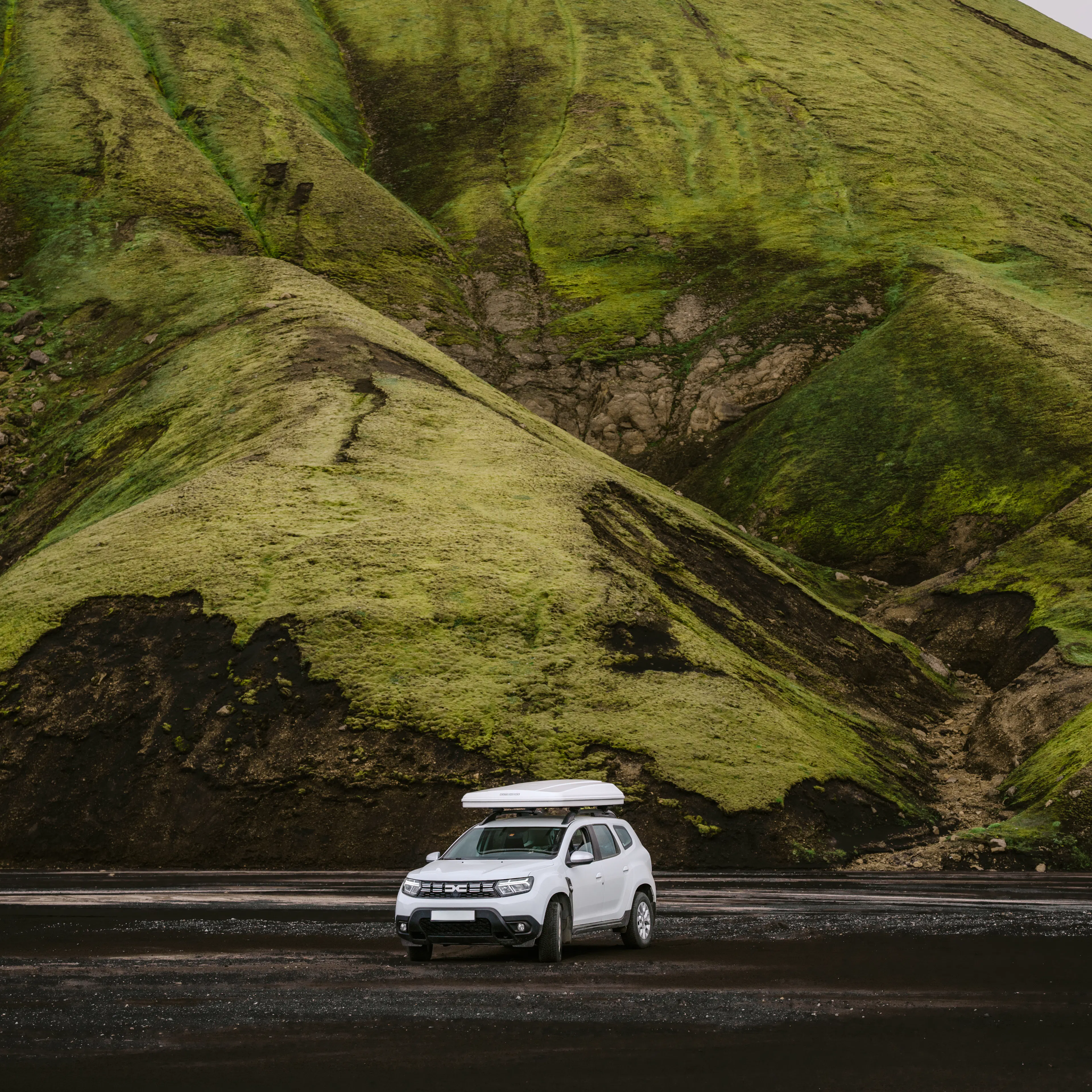 White suv rooftent green mossy mountain