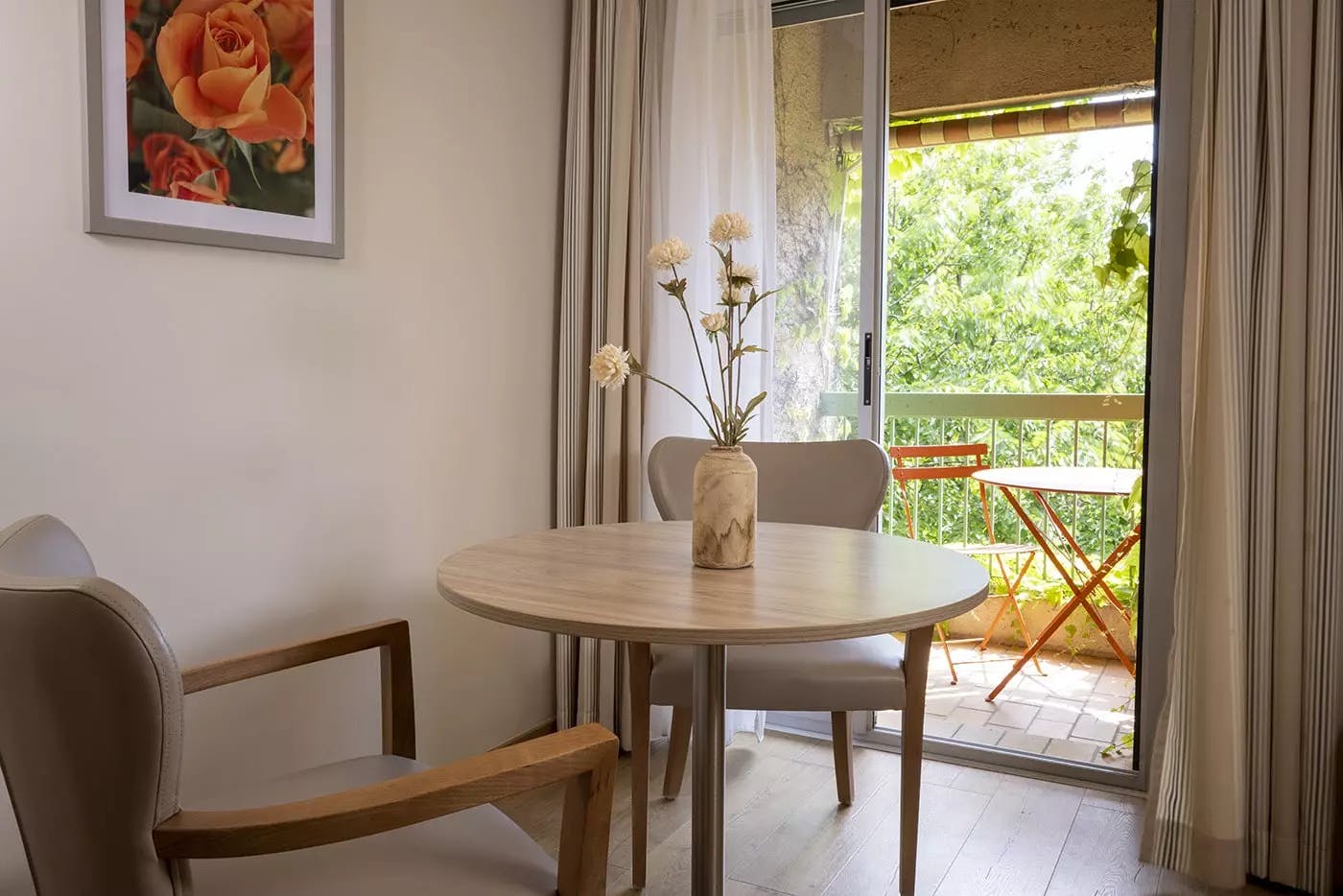 Petite table et des chaises à côté d'un balcon | Lou Paradou Hôtel | Gréoux-les-Bains
