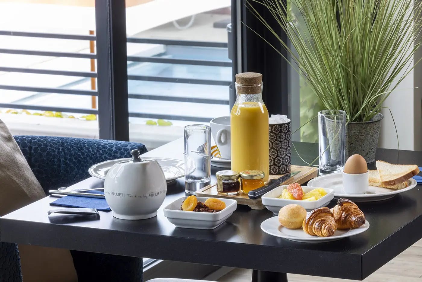 Un petit-déjeuner installé sur une table devant une fenêtre | Lou Paradou Hôtel | Gréoux-les-Bains