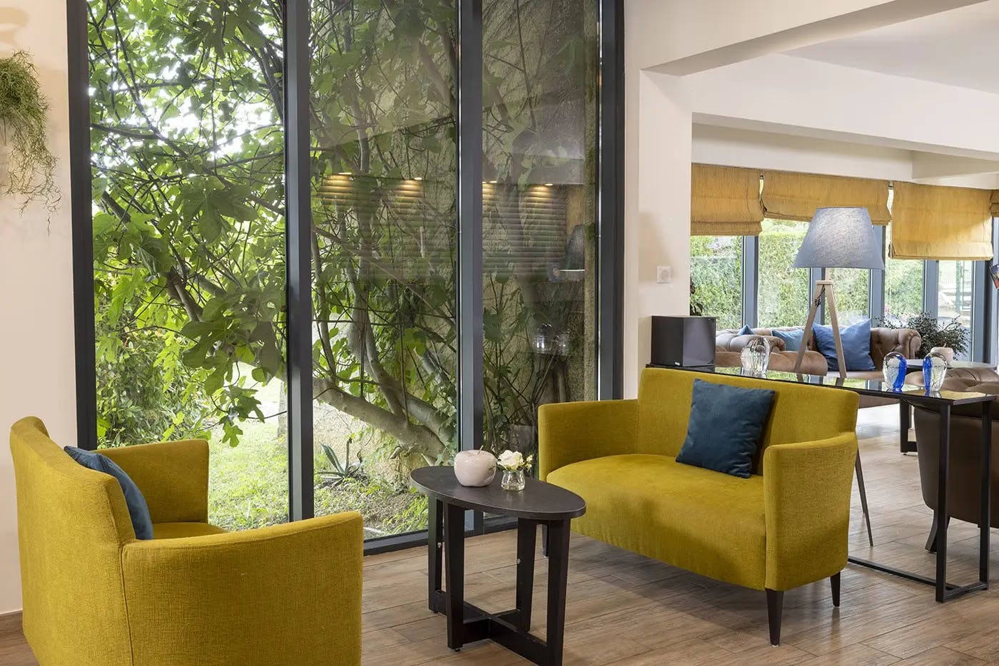 Salon avec un canapé jaune et une table basse | Lou Paradou Hôtel | Gréoux-les-Bains