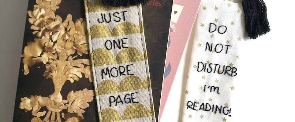 Two fabric bookmarks resting on books