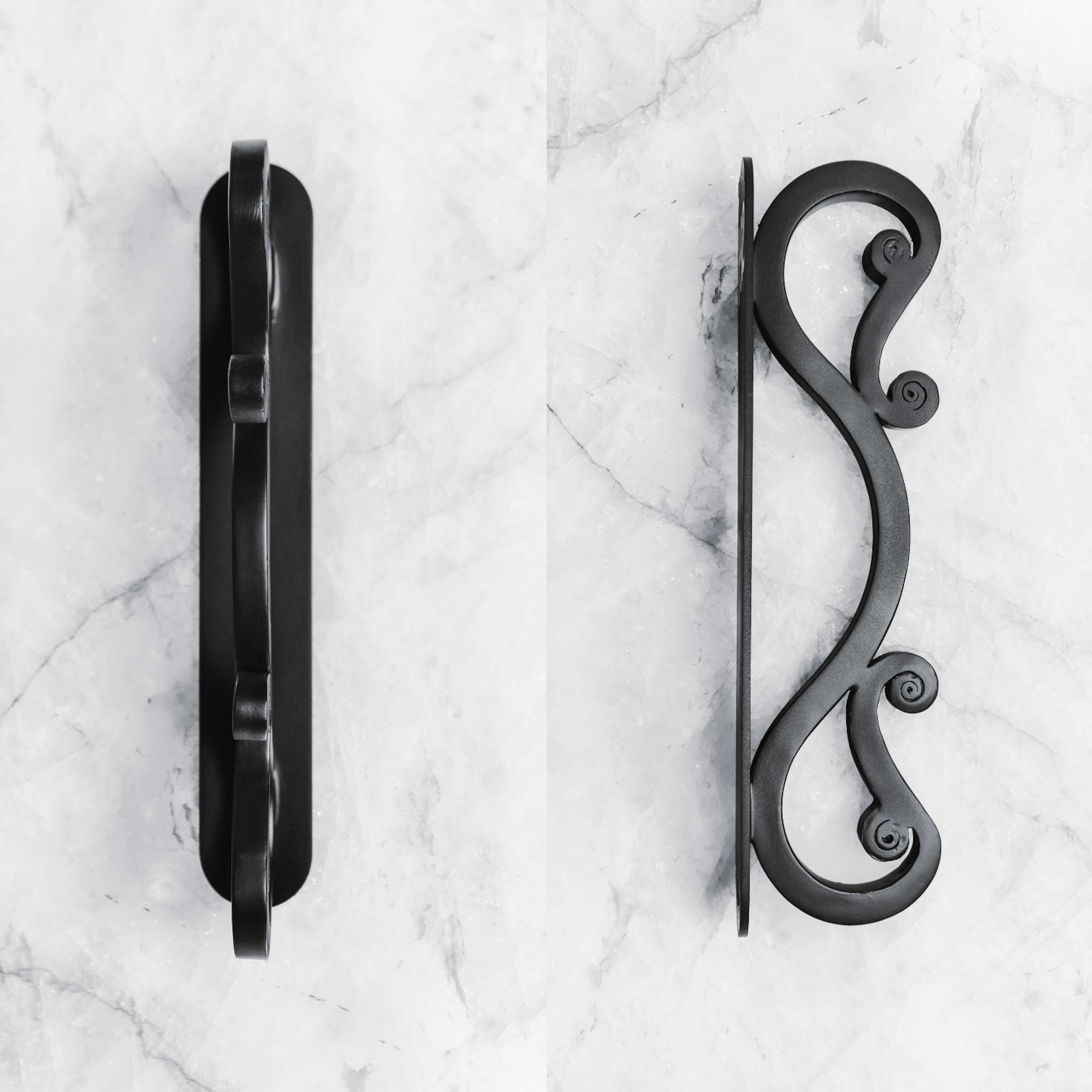 Iron door pulls with ornate scrollwork and vintage charm