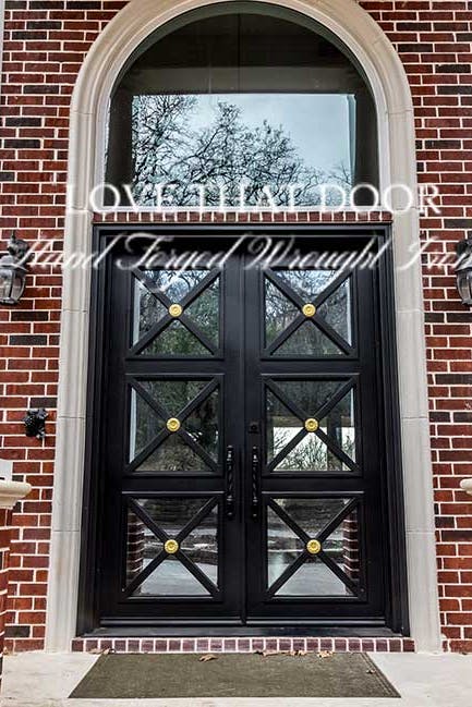 Luxurious iron entryway with transom window, exuding timeless charm and sophistication.