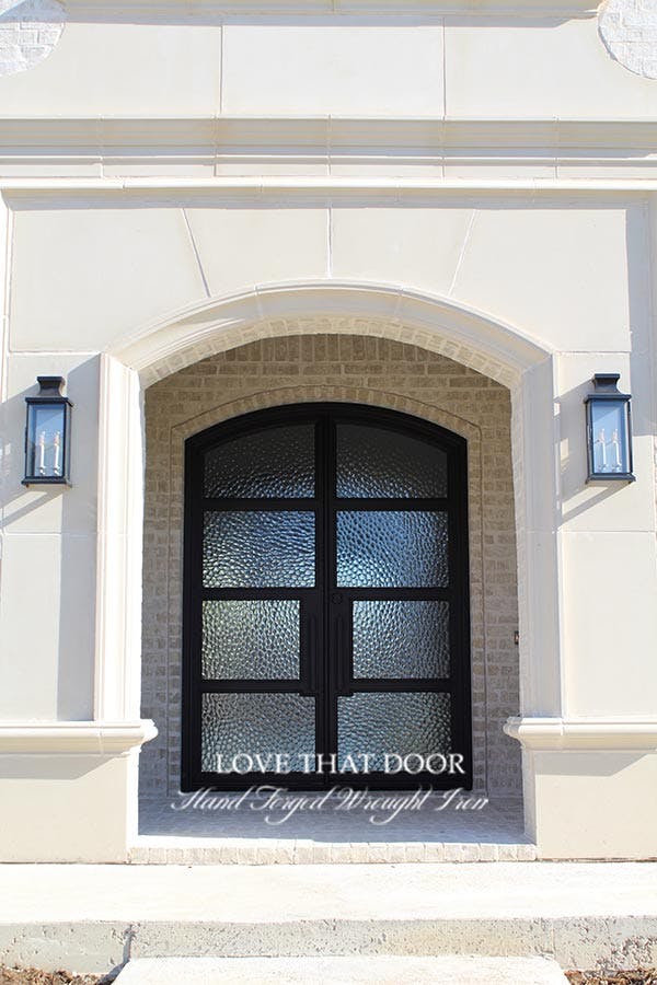 Elegant iron double doors with arched glass panels and timeless appeal
