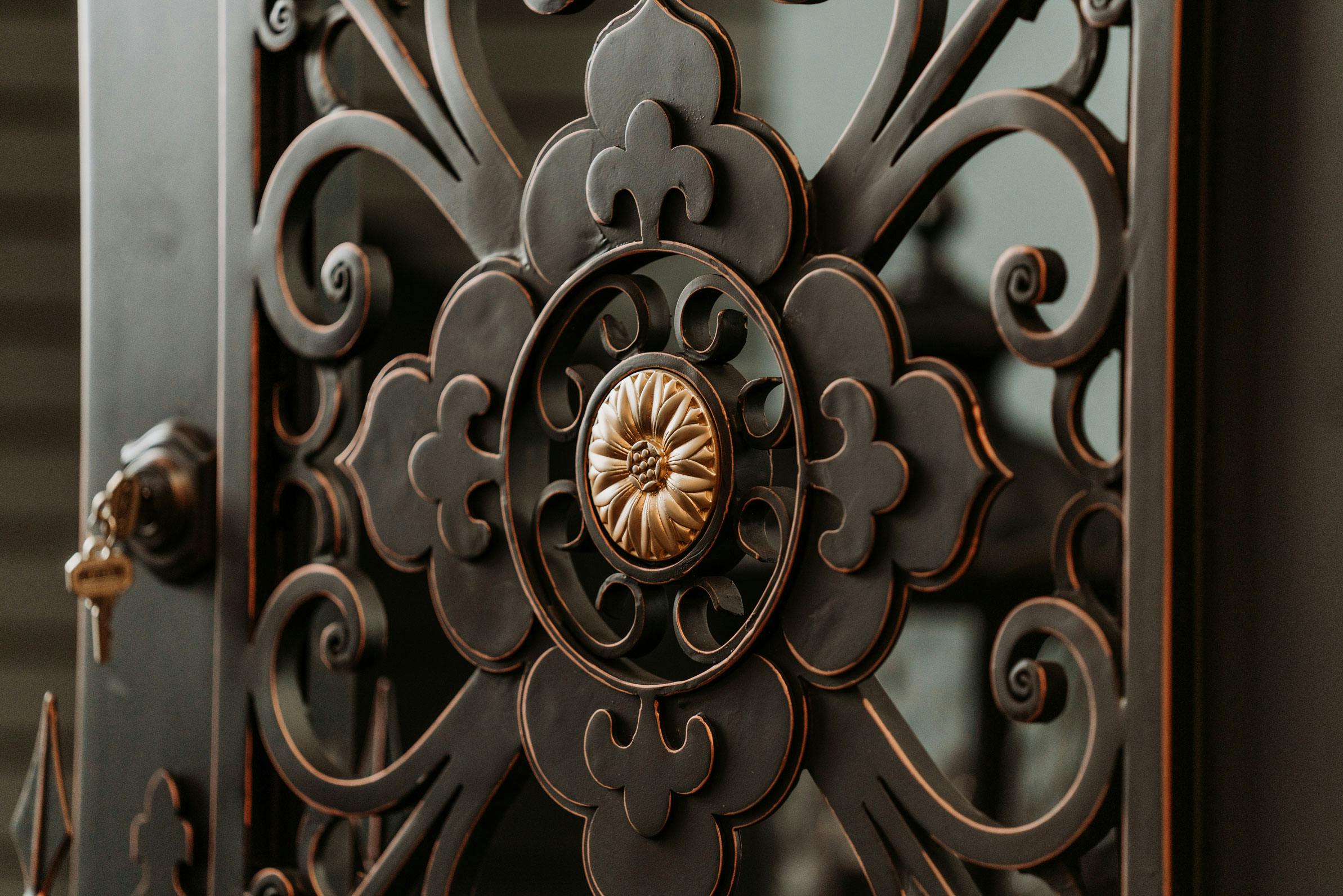 Handcrafted custom wrought iron door with intricate scrollwork and arched top