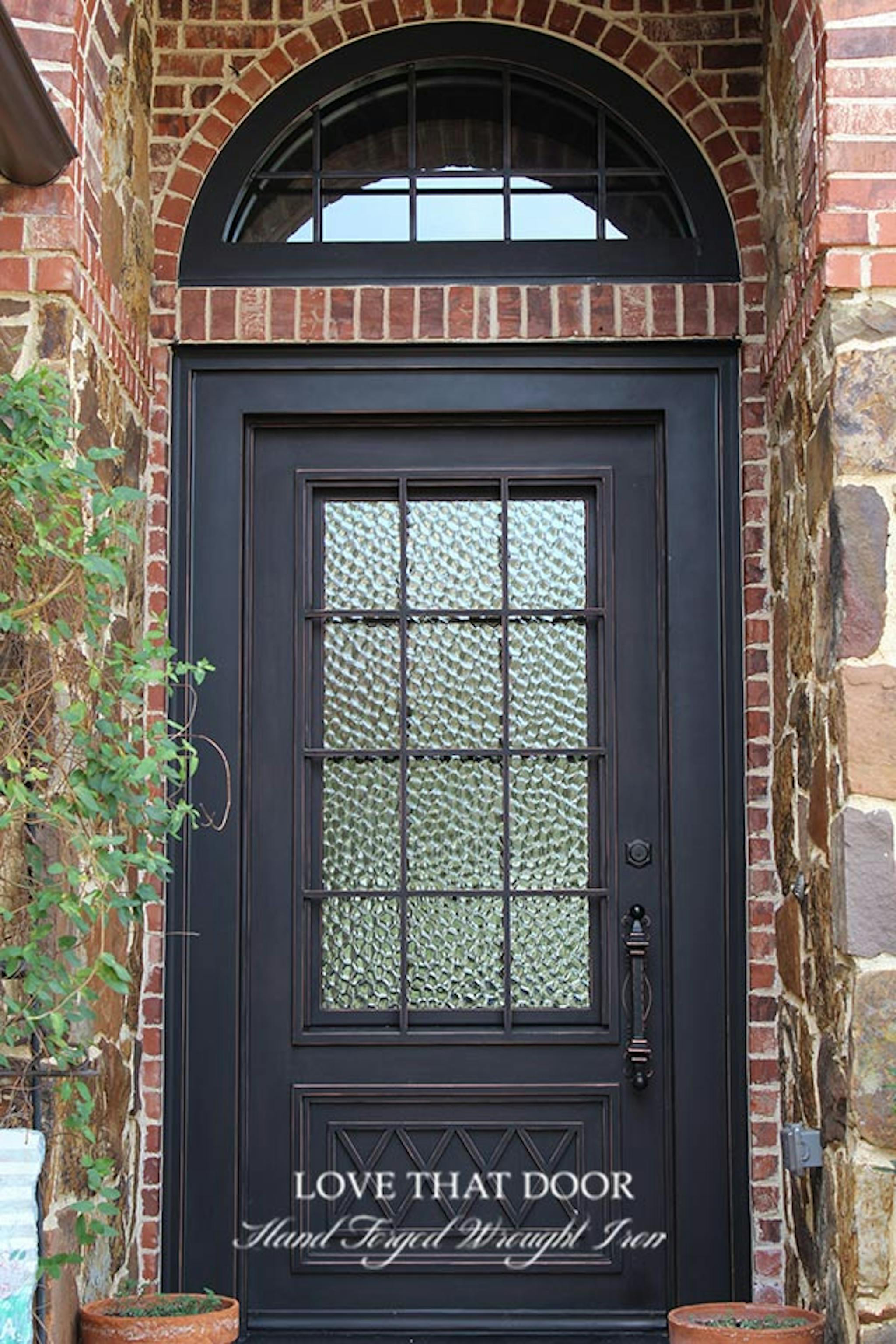 Magnificent iron door with transom window, offering an inviting entryway with an air of sophistication.