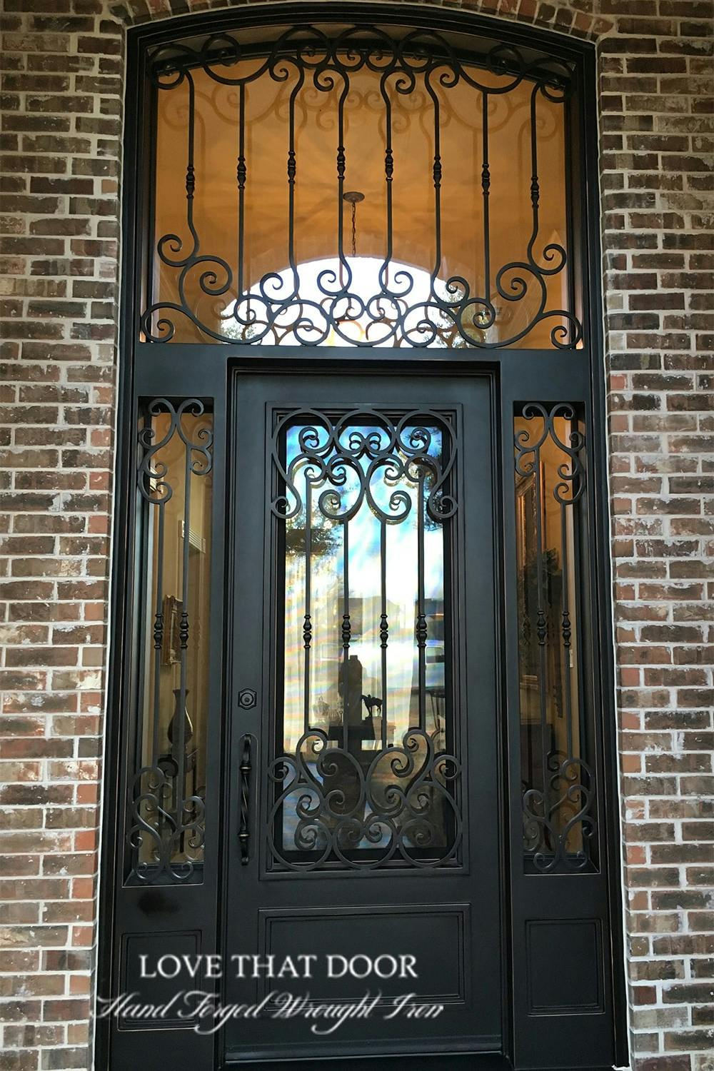 Artisan-crafted iron door and transom ensemble, exhibiting meticulous attention to detail.