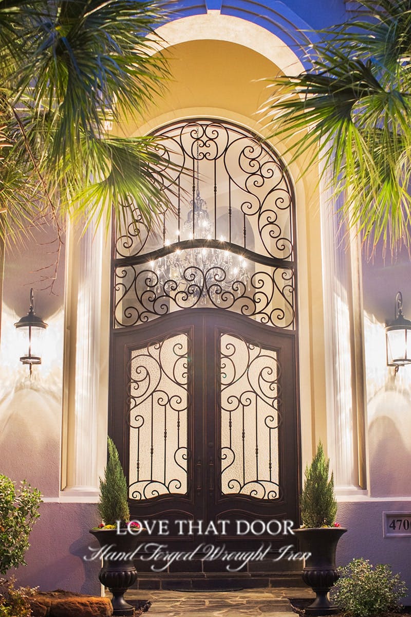 Striking iron door and transom with stained glass accents, infusing your entryway with color.