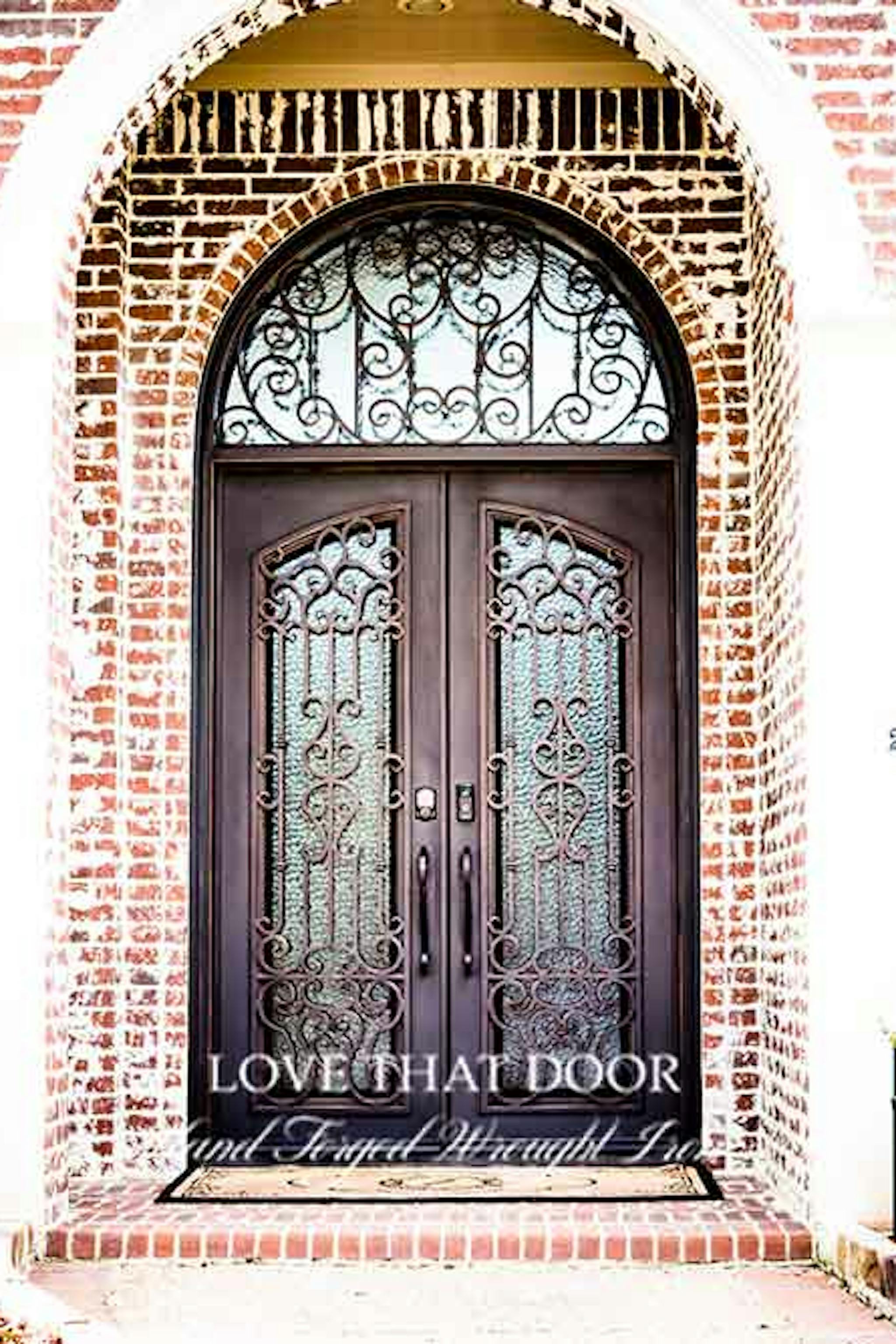 Stunning iron door and transom combination, boasting intricate floral motifs and glass inserts.