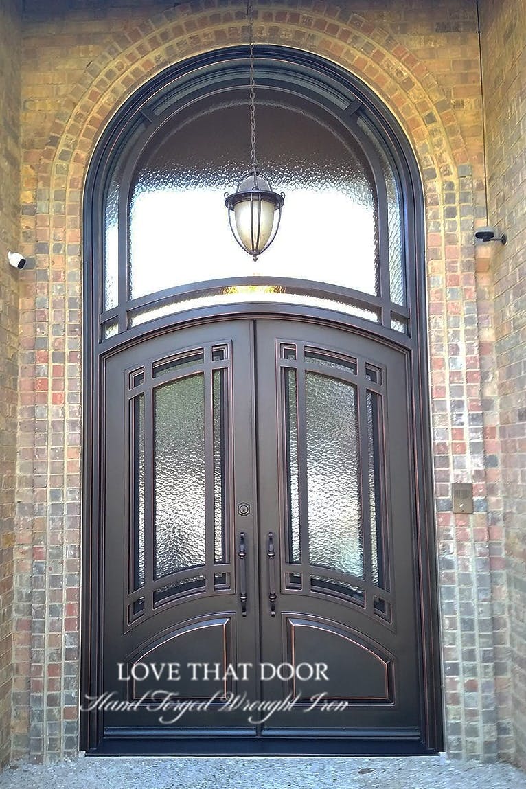 Majestic iron entry door and transom, showcasing a harmonious blend of strength and elegance.