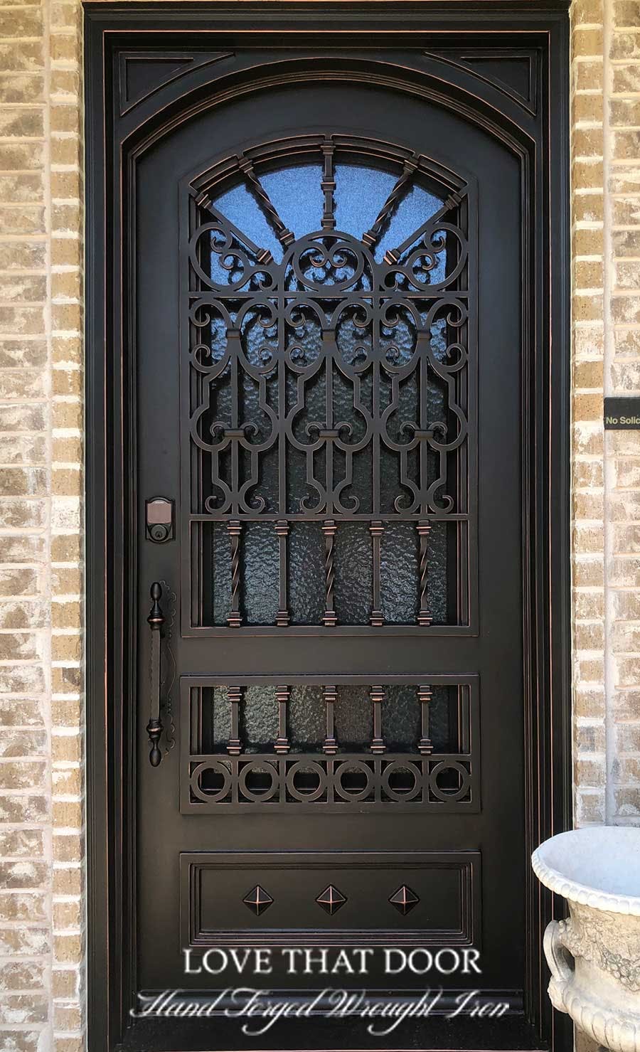 Single iron front door with decorative grillwork and patterns