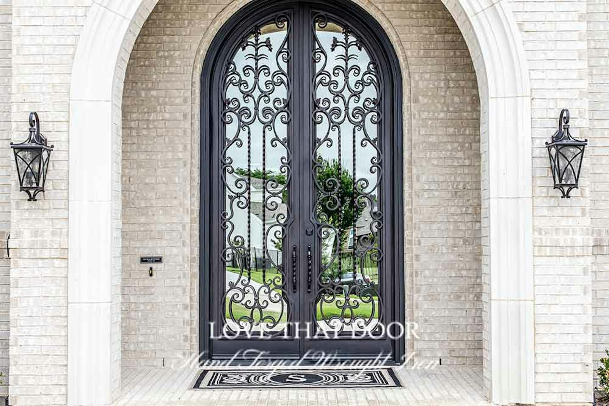 Iron double doors with decorative grillwork and patterns for added charm