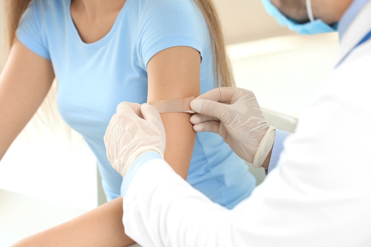 Doctor vaccinating young woman in clinic
