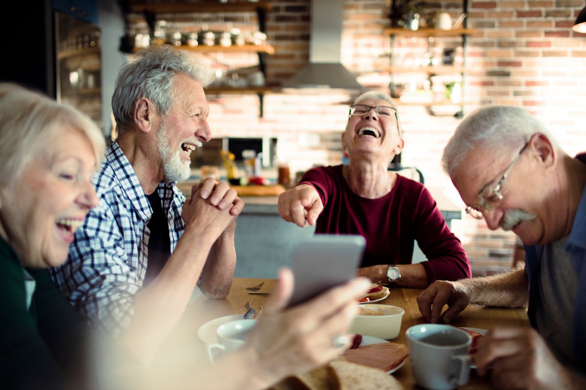 Happy senior people eating together at home
