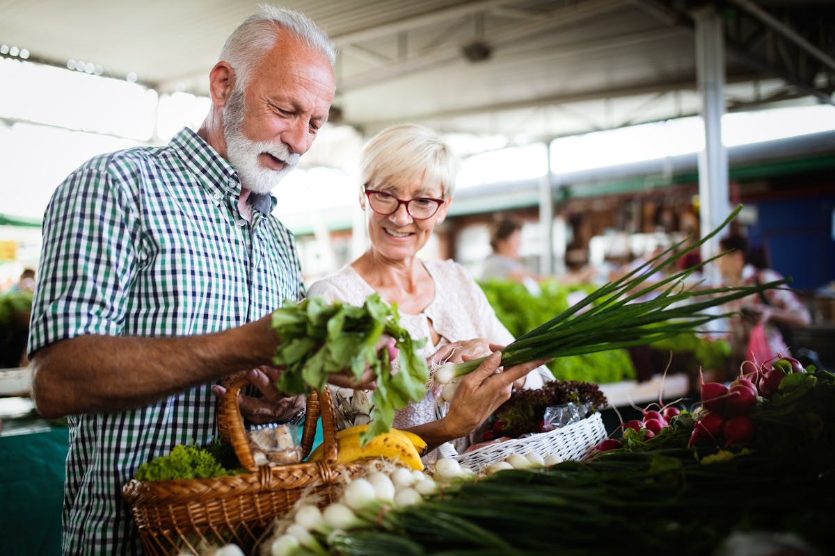 Mature couple shopping vegetables and fruits on the market. Healthy diet.