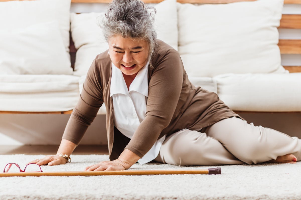 Asian senior woman falling down lying on floor at home alone. Elderly woman pain and hurt from osteoporosis sickness or heart attack. Old adult life insurance with hearlth care and treatment concept