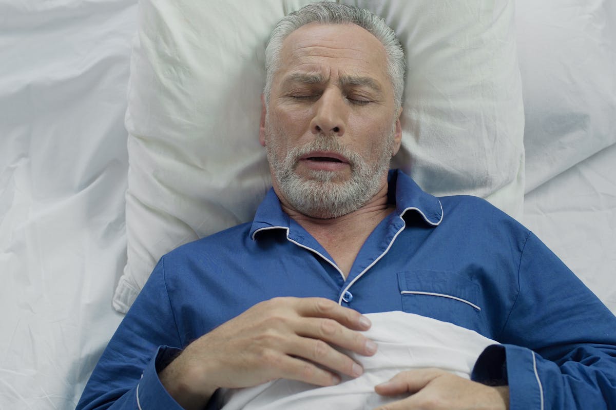 Aged male loudly snoring and puffing in bed, sleeping problems at old age