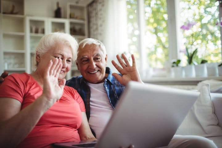 Senior couple video chatting on laptop
