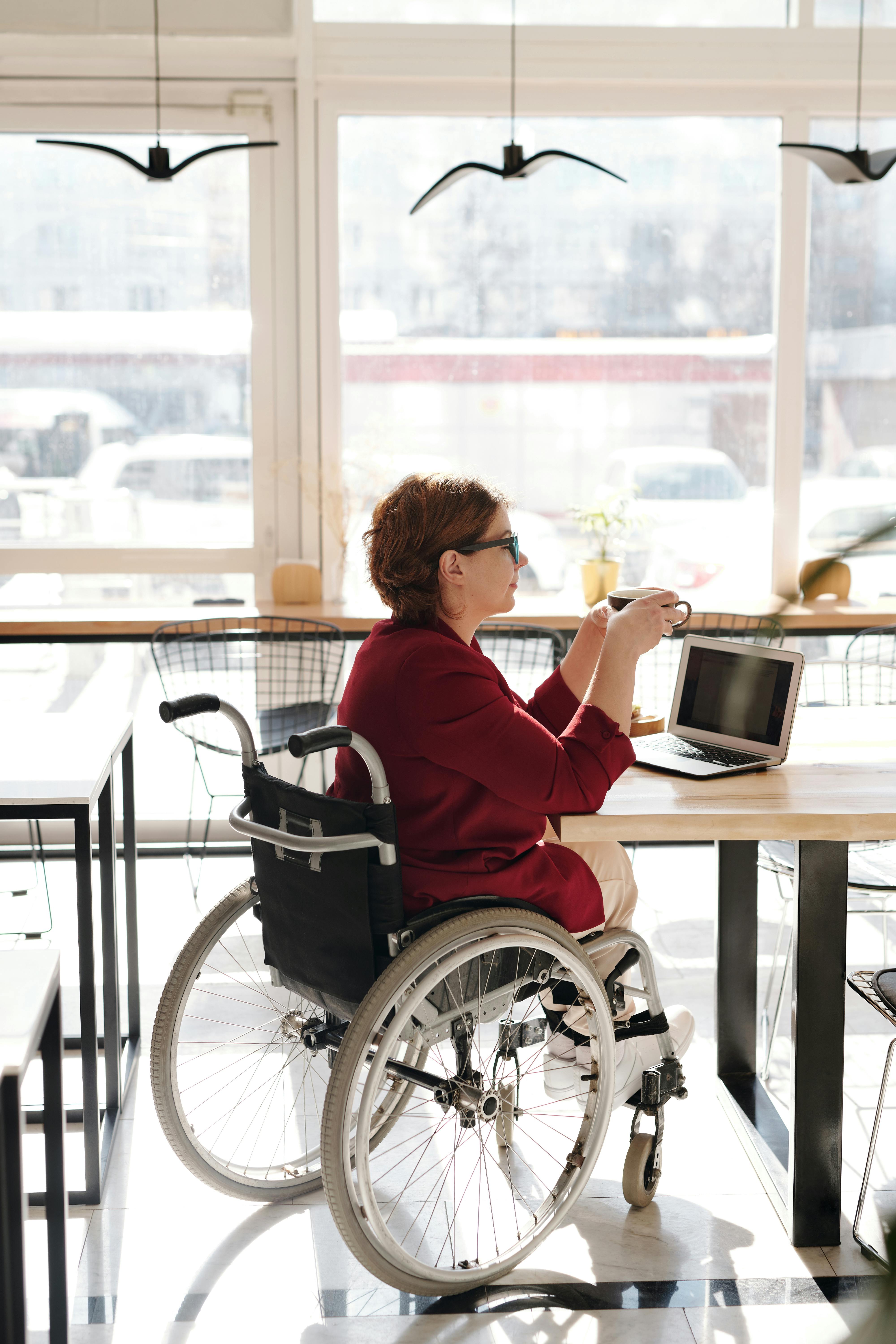 lady in a wheelchair having coffee with her computer