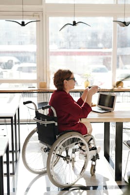 lady in a wheelchair having coffee with her computer