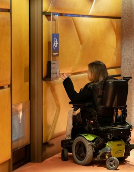 woman in wheel chair interacting with touch screen