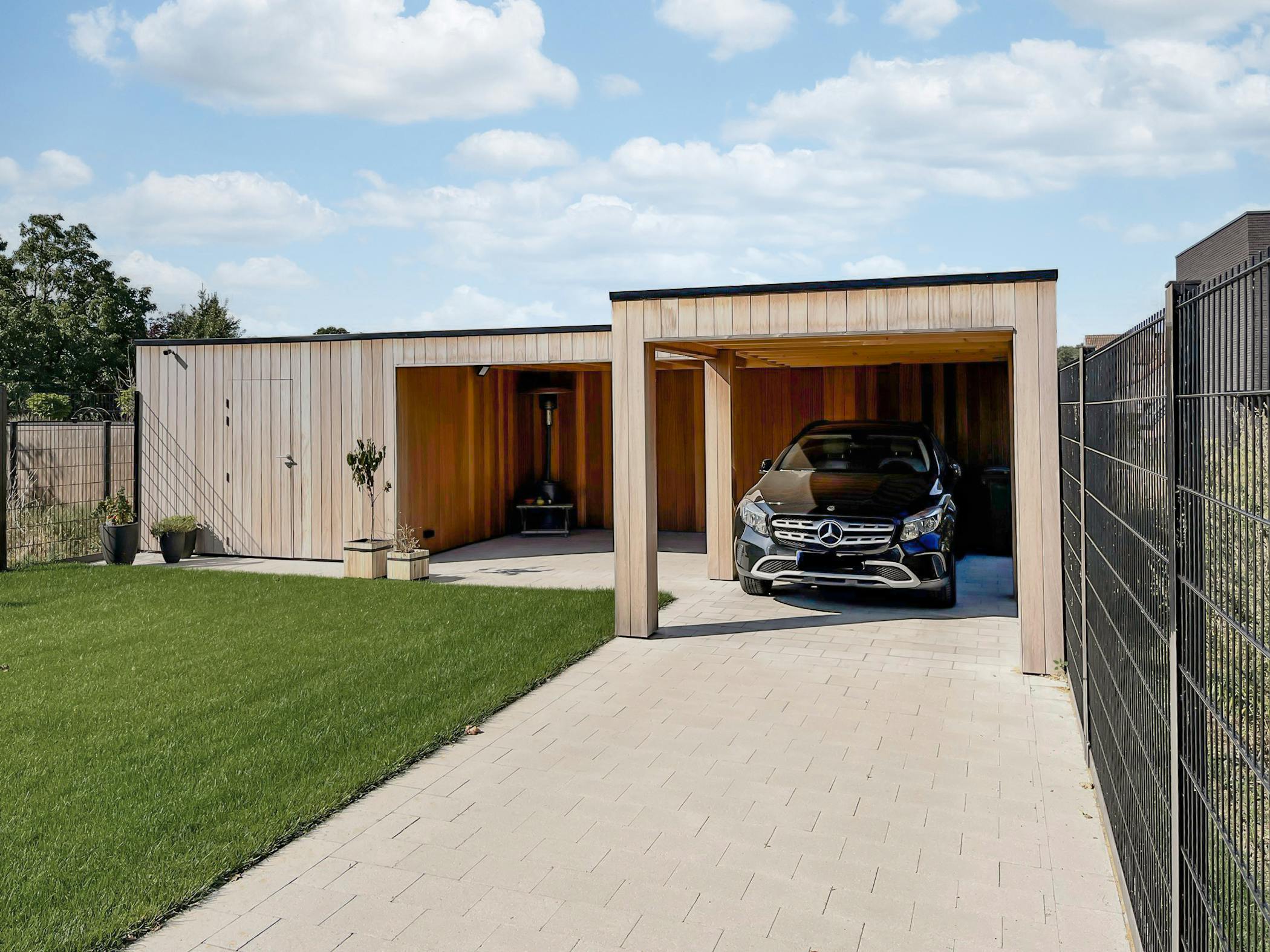 Strak tuinhuis met terras en carport in hoekvorm